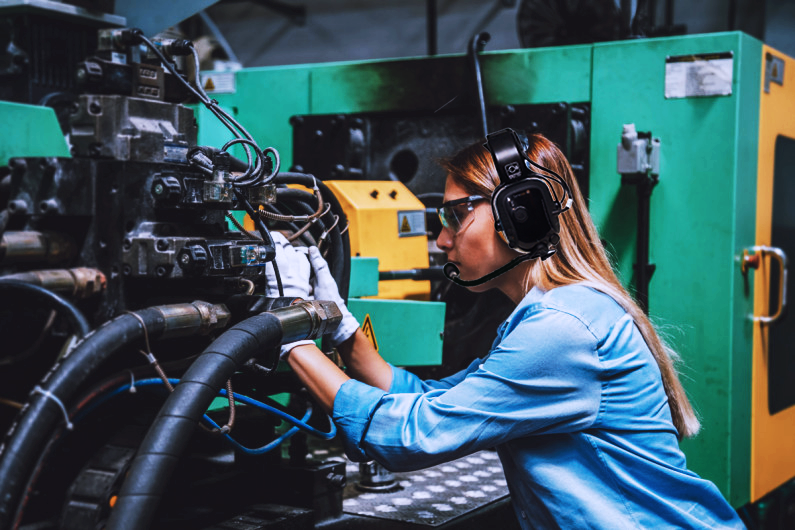 A-female-engineer-repairing-a-production-line-machine
